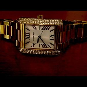 Michael Kors gold tone crystal bezel tonneau shaped ladies watch.
